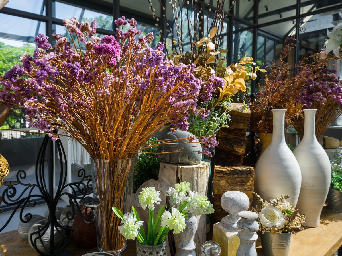 Flower shop display with ceramic and glass vases, dried flowers and planters